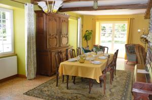 comedor con mesa y mantel amarillo en Moulin de la Cuse - Chambre La Cuse, en Cusance