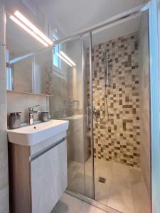 a bathroom with a sink and a shower at Memoria Apartments by Imagine Lefkada in Lefkada Town