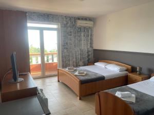 Habitación de hotel con 2 camas y balcón en Budva Metaxi Suits en Budva