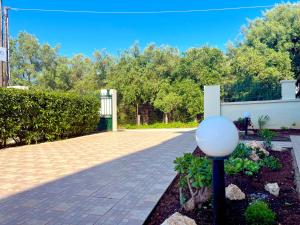 a garden with a lamp in the middle of a driveway at Memoria Apartments by Imagine Lefkada in Lefkada Town