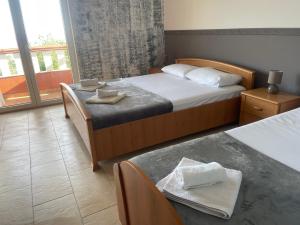 Habitación de hotel con 2 camas y ventana en Budva Metaxi Suits en Budva