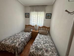 - une chambre avec 2 lits et une fenêtre dans l'établissement Apartamento Pascual, à Torrevieja