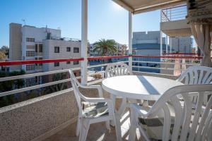 a white table and chairs on a balcony at AT016 Piscina con césped, airco, playa a pocos pasos in Torredembarra