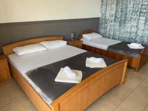 Dos camas en una habitación de hotel con toallas. en Budva Metaxi Suits en Budva