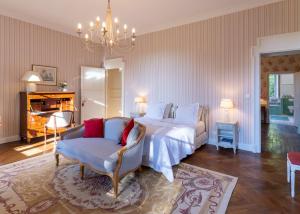 1 dormitorio con 1 cama, 1 silla y 1 lámpara de araña en Château de la Marronnière, en Aizenay
