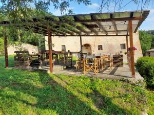 a wooden pergola with a table in a yard at Tipico casolare toscano Tenuta della Selva in Murlo