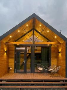 une maison avec deux chaises et une table sur une terrasse dans l'établissement Mini Valley House 1, à Sita Buzăului