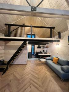 - un salon avec un canapé bleu et un escalier dans l'établissement Mini Valley House 1, à Sita Buzăului