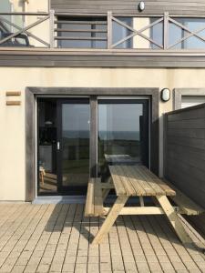 a wooden bench sitting on the side of a house at charmant studio vue mer in Wimereux