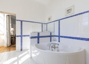 Château de la Marronnière في Aizenay: حمام أبيض مع جدران من البلاط الأزرق وحوض استحمام +40 صورة