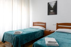 sypialnia z 2 łóżkami i ręcznikami w obiekcie Yani's Hospedaje w mieście Arriondas