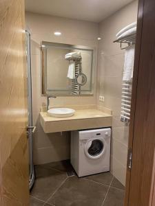 a bathroom with a washing machine and a sink at Dreamland Oasis Apartment 614 in Chakvi