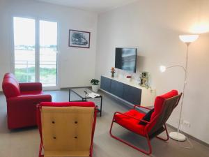 ein Wohnzimmer mit roten Stühlen und einem TV in der Unterkunft ROGOS Casa Vacanze in Ragusa