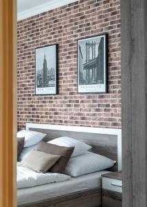 un mur de briques avec quatre oreillers sur un banc dans l'établissement Apartman Nobilis, à Hévíz