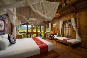 ein Schlafzimmer mit einem großen Bett und einem Balkon in der Unterkunft Puluong Valley Home in Thanh Hóa