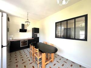 eine Küche mit Tisch und Stühlen in einem Zimmer in der Unterkunft Charmante charentaise in Saint-Jean-dʼAngély