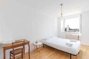 um quarto com uma cama, uma secretária e uma janela em Cabana & Grand appartement cosy - Parking & Balcon em Villefranche-sur-Saône