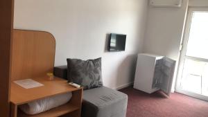 um quarto com uma cadeira, uma secretária e uma televisão em Anacor em Dubova