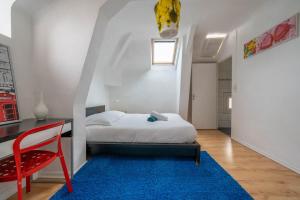 - une chambre avec un lit et une chaise rouge dans l'établissement Alexandra Apartments, à Digne-Les-Bains