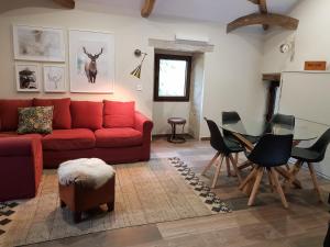 a living room with a red couch and a table at EL VIEJO MOLINO in Lugo