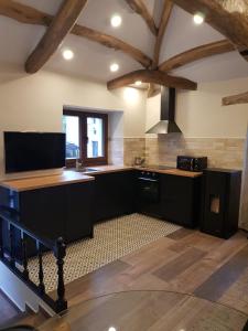 a large kitchen with black cabinets and a sink at EL VIEJO MOLINO in Lugo