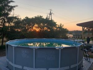 a small swimming pool with the sunset in the background at Mazurski dom Brejdyny Sauna i Bania in Mrągowo