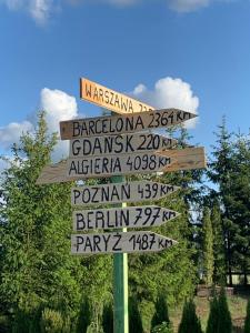 a street sign with many signs in different languages at Mazurski dom Brejdyny Sauna i Bania in Mrągowo