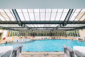 a large indoor swimming pool with people in it at Saigon Dalat Hotel in Da Lat