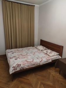 um pequeno quarto com uma cama com uma cortina em Kufer Flat em Lviv