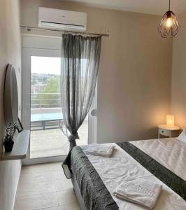 a bedroom with a bed and a window with a balcony at Korina's Apartment in Daratso