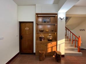 a hallway with a wooden door and stairs with vases at 觀心農舍 民宿 Ageless Farmhouse in Sanyi