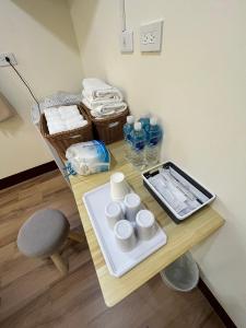 a table with cups and bottles and a chair at 觀心農舍 民宿 Ageless Farmhouse in Sanyi