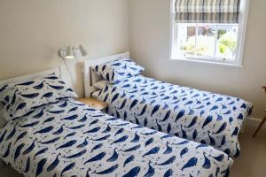 a bedroom with two beds and a window at Bumblebee cottage Exmouth in Exmouth