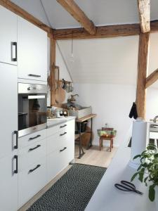 une cuisine avec des placards blancs et une table dans l'établissement Appartment Kornboden Nordic Style, à Schopfheim