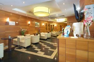 a waiting room with white chairs and a checkerboard floor at Briz - Seabreeze Hotel in Sunny Beach +50 photos
