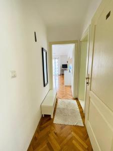 a room with a hallway with a couch and a door at GARDEN BECICI in Bečići