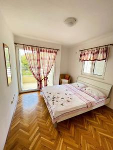 a bedroom with a bed and a large window at GARDEN BECICI in Bečići
