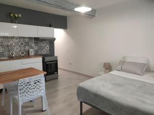 1 dormitorio con cama, mesa y cocina en Studio Entier en Saint-Laurent-dʼAigouze