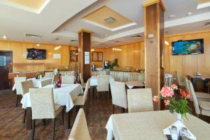 un restaurant avec des tables et des chaises blanches et un bar dans l'établissement Briz - Seabreeze Hotel, à Sunny Beach
