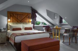 a bedroom with a large bed and a staircase at The Crown Inn Pooley Bridge in Pooley Bridge