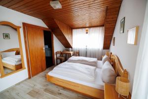 a bedroom with a bed and a mirror at Drexl Gasthof Shiro in Schondorf am Ammersee