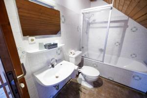 een badkamer met een wastafel, een toilet en een douche bij Drexl Gasthof Shiro in Schondorf am Ammersee