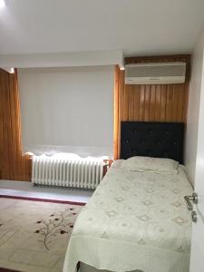 um quarto com uma cama e uma janela com um radiador em Şişli merkezde Cevahir’e yakın em Istambul