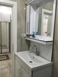 uma casa de banho com um lavatório e um espelho em Şişli merkezde Cevahir’e yakın em Istambul
