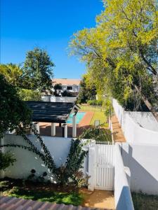 a view of the backyard of a house with a white fence at Comfy Zone Apartment in Gaborone