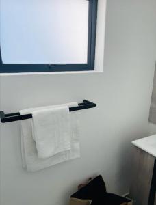 a bathroom with white towels hanging on a towel rack at Comfy Zone Apartment in Gaborone