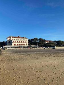 un bâtiment sur la plage avec des empreintes de pieds dans le sable dans l'établissement Studio de 21m2 au moulleau à 20 m de la plage, à Arcachon 6 autres photos