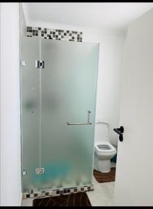 a bathroom with a glass shower with a toilet at Comfy Zone Apartment in Gaborone