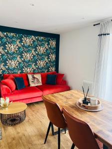 a living room with a red couch and a table at The Little Cottage by Truabode Holiday Lets & Short Lets Newquay - Parking, Wifi & Pet Friendly in Newquay