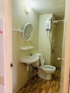 y baño con aseo, lavabo y espejo. en For rent condo popular T8 fl9 en Thung Si Kan
